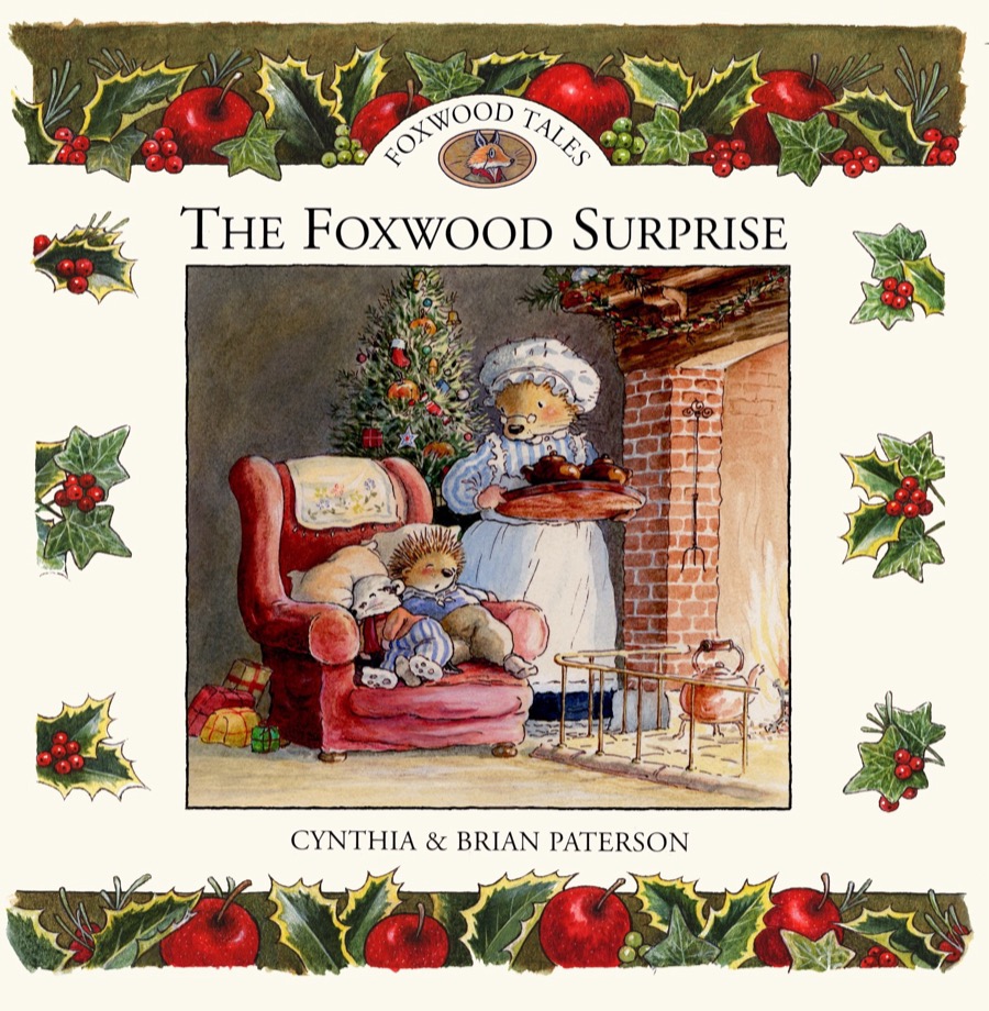 Cover artwork of The Foxwood Surprise: a grandmother hedgehog serves pudding by the fireplace to little ones in an armchair, framed by holly and apples